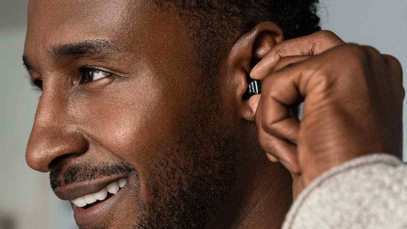 Man inserting a tiny Sony CRE-C20 hearing aid in ear