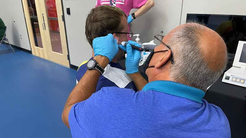 Starkey Cares provided over 100 Special Olympics athletes with hearing aids this June at the 2022 Special Olympics USA Games. Pictured here, Starkey Cares volunteer David Kelley assists Special Olympics athlete Patrick Davis.