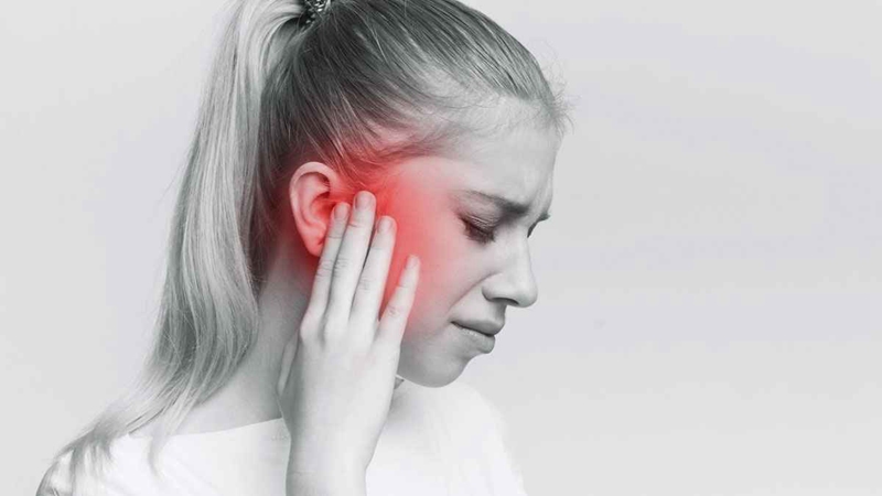 A young woman suffers from tinnitus