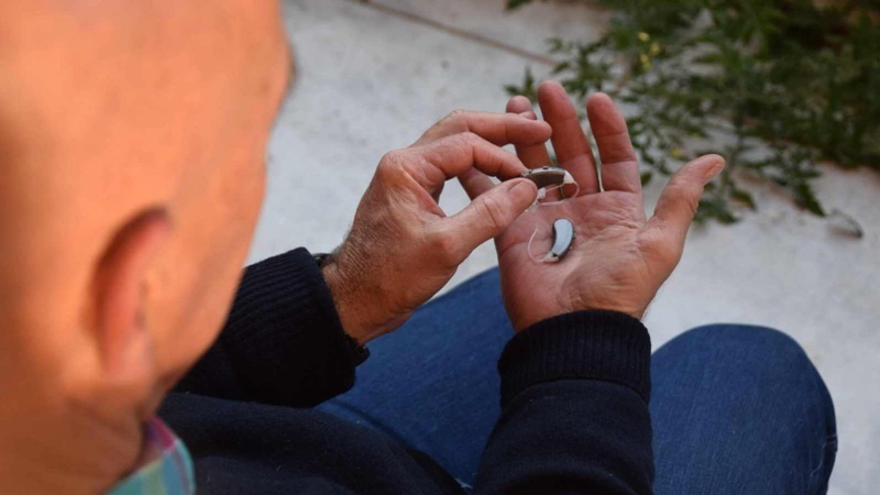 Man holding OTC hearing aids from Walgreens